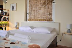 una camera da letto con un letto con lenzuola bianche e una finestra di Funky Nest - A cozy apartment in Zipari a Città di Kos