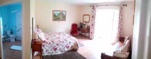 a bedroom with a bed and a door to a bathroom at Le Presbytère de Vieuvy 