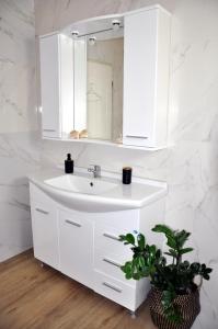 bagno bianco con lavandino e specchio di Funky Nest - A cozy apartment in Zipari a Città di Kos