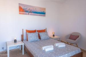 a bedroom with a bed with two tables and a chair at Sirocco Pool House in Carvoeiro