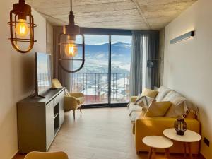 a living room with a yellow couch and a large window at ELS 4 PICS in Puigcerdà