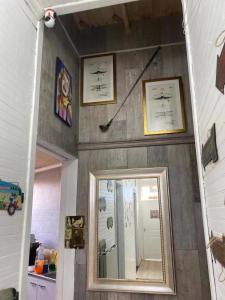 Hostal el Idilio في كارتاخينا: حمام مع مرآة وصور على الحائط