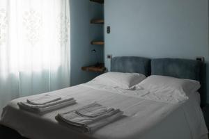 a bed with two towels on top of it at La Stalla de La Costa in Asciano