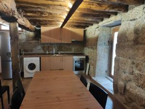 cocina con mesa de madera en una habitación en Casa dos Conchos Sabugueiro Casa com 4 quartos en Sabugueiro
