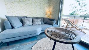a living room with a couch and a table at Voiron centre, grande terrasse, parking, calme in Voiron