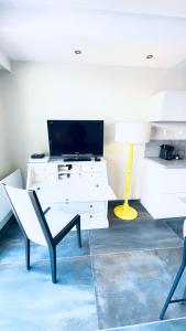 a living room with a white desk and a tv at Voiron centre, grande terrasse, parking, calme in Voiron