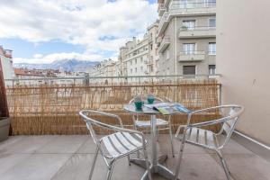 a table and chairs on a balcony with a view at Paul Janet in Grenoble