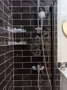 y baño con ducha de azulejos negros en Modern Apartment in the Heart of the City - Fatih en Estambul