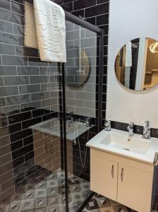 W łazience znajduje się prysznic, umywalka i lustro. w obiekcie Modern Apartment in the Heart of the City - Fatih w Stambule