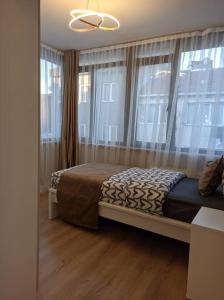 a bedroom with a bed in a room with windows at Modern Apartment in the Heart of the City - Fatih in Istanbul