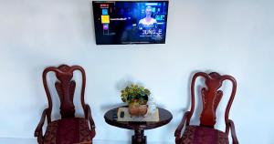 two chairs and a table with a tv on a wall at Cozy 2BR Near Playa Dorada, 3 Min In Car in San Felipe de Puerto Plata