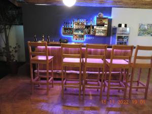 a bar with four chairs and a counter with drinks at Karanga River Lodge in Moshi