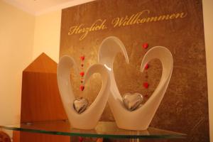 szklany stół z dwoma wazami w kształcie serca w obiekcie Haus Hubertus w mieście Bad Peterstal-Griesbach