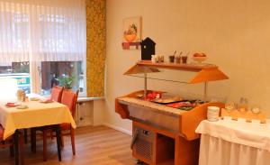 a kitchen with a stove with a table and two tables at Haus Hubertus in Bad Peterstal-Griesbach