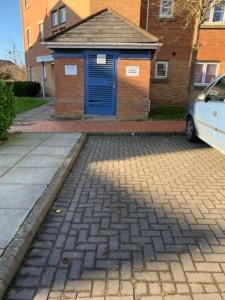 a building with a blue door on a brick street at Modern Apartment in Barry Waterfront in Barry