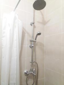 y baño con ducha con cabezal de ducha. en Appartement entier proche de Paris., en Clichy