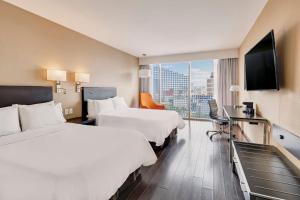 a hotel room with two beds and a flat screen tv at Fiesta Inn Insurgentes Viaducto in Mexico City