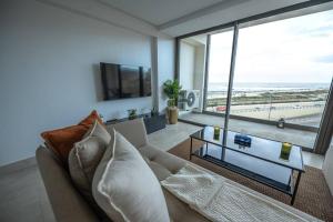 a living room with a couch and a large window at Apartment Sea View B11 - Mosquée Hassan II - By TheCasaEdition in Casablanca