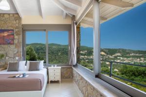 a bedroom with a bed and large windows at Silencio Villas in Lefkada