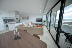 a kitchen and a living room with a wooden table at Apartment Sea View B11 - Mosquée Hassan II - By TheCasaEdition in Casablanca