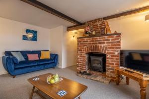 a living room with a fireplace and a blue couch at The Town House in Woodbridge +32 photos