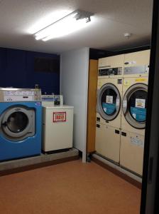 een wasruimte met 2 wasmachines bij Matsue Urban Hotel in Matsue