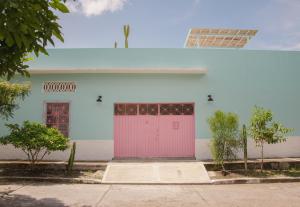 um edifício branco com uma porta rosa em Casa Celeste Honda em Honda