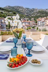 a table with plates of fruit on a table with a view at Penthouse Exceptionnel vue Mer proche Monaco in Beausoleil
