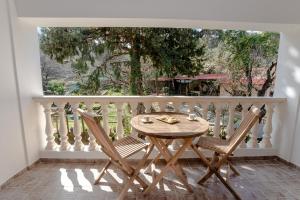 a table and two chairs on a balcony with a window at Anna's Country Villa Privé in Karés