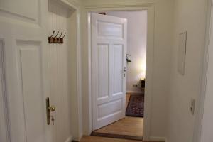 a hallway with a white door and a wooden floor at Wiesengrund in Bad Harzburg