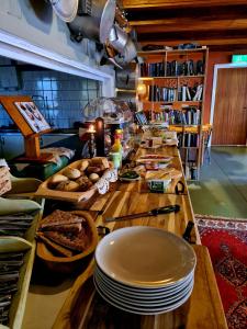 a long table with plates and bread on it at HOSTEL and VANDRARHEM LUPIN Naturcamping Lagom in Gräsmark