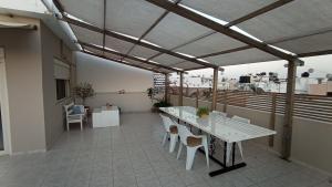 een patio met een tafel en stoelen op een balkon bij Cosy Roof Room in Ierápetra