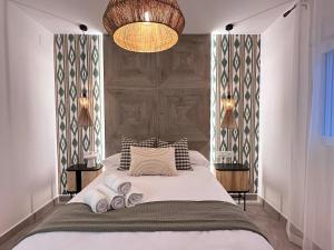 Apartamentos la Mariana في غرناطة: غرفة نوم عليها سرير وفوط