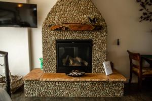 sala de estar con chimenea de piedra en Origins Bed and Breakfast en Cottonwood