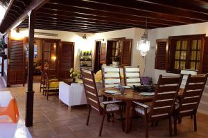 a dining room with a wooden table and chairs at Villa a pie de mar in Costa Teguise