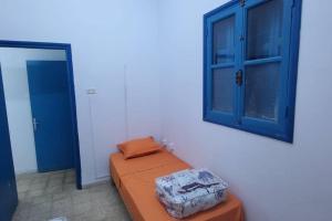 a bedroom with an orange bed and a blue cabinet at Studio Pratique bonne proximité in Sfax