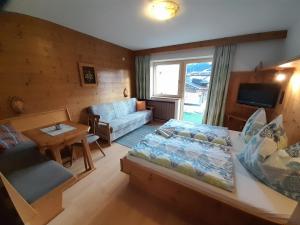 uma sala de estar com uma cama e um sofá em Haus Rosenegg em Brixen im Thale