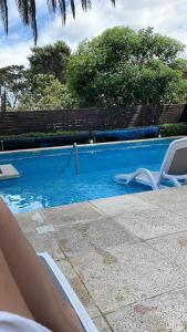 una persona tumbada en una silla junto a una piscina en Summer Tower 102, en Punta del Este