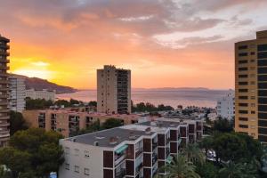 um horizonte da cidade com edifícios e o oceano ao pôr do sol em Espectacular Ático con excelentes vistas. em Almeria