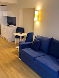 ein Wohnzimmer mit einem blauen Sofa und einem Tisch in der Unterkunft The best beach aparthotel Orbi city Batumi in Batumi