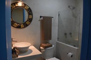 La salle de bains est pourvue d'un lavabo, de toilettes et d'un miroir. dans l'établissement LUNA AZUL BY UVAS, à Cozumel