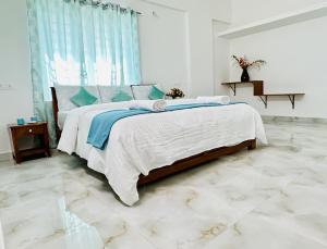 a bedroom with a large bed with blue and white sheets at Tirupati Homestay - Shilparamam - Luxury AC apartments by Stayflexi - Fast WiFi, Kitchen, Android TV - Walk to PS4 Pure Veg Restaurant - Easy access to Airport, Railway Station and to all Temples in Tirupati