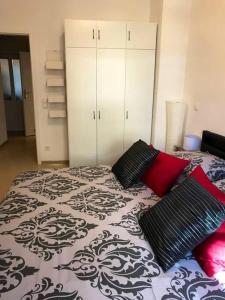 Schlafzimmer mit einem Bett mit schwarzen und roten Kissen in der Unterkunft Apartment „La Casa de Papel“ / Behindertengerecht in Leipzig
