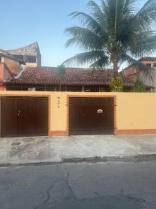 una casa con dos puertas de garaje y una palmera en Hostel Guirlanda, en Río de Janeiro