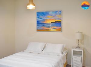 a bed in a room with a painting on the wall at Casa Jaguar in Puerto Peñasco