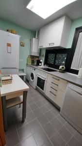 a kitchen with white appliances and a table in it at Vivienda Uso Turístico Las Gemelas de Arevalo in Arévalo