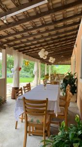 une salle à manger avec une table et des chaises blanches dans l'établissement Sítio Maranata Vale das Montanhas, à Monte Alegre do Sul