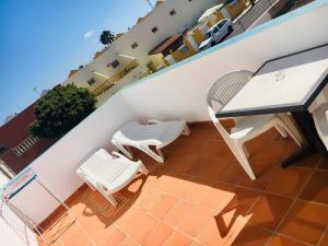 a balcony with a table and chairs on a building at La Casita di Fuerte in Caleta De Fuste