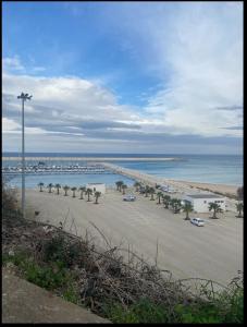een strand met auto's geparkeerd op het zand en de oceaan bij Casa Balestrate in Balestrate