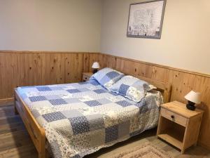 a bedroom with a bed with a blue and white quilt at CABAÑAS ANAHUAC in Puerto Montt